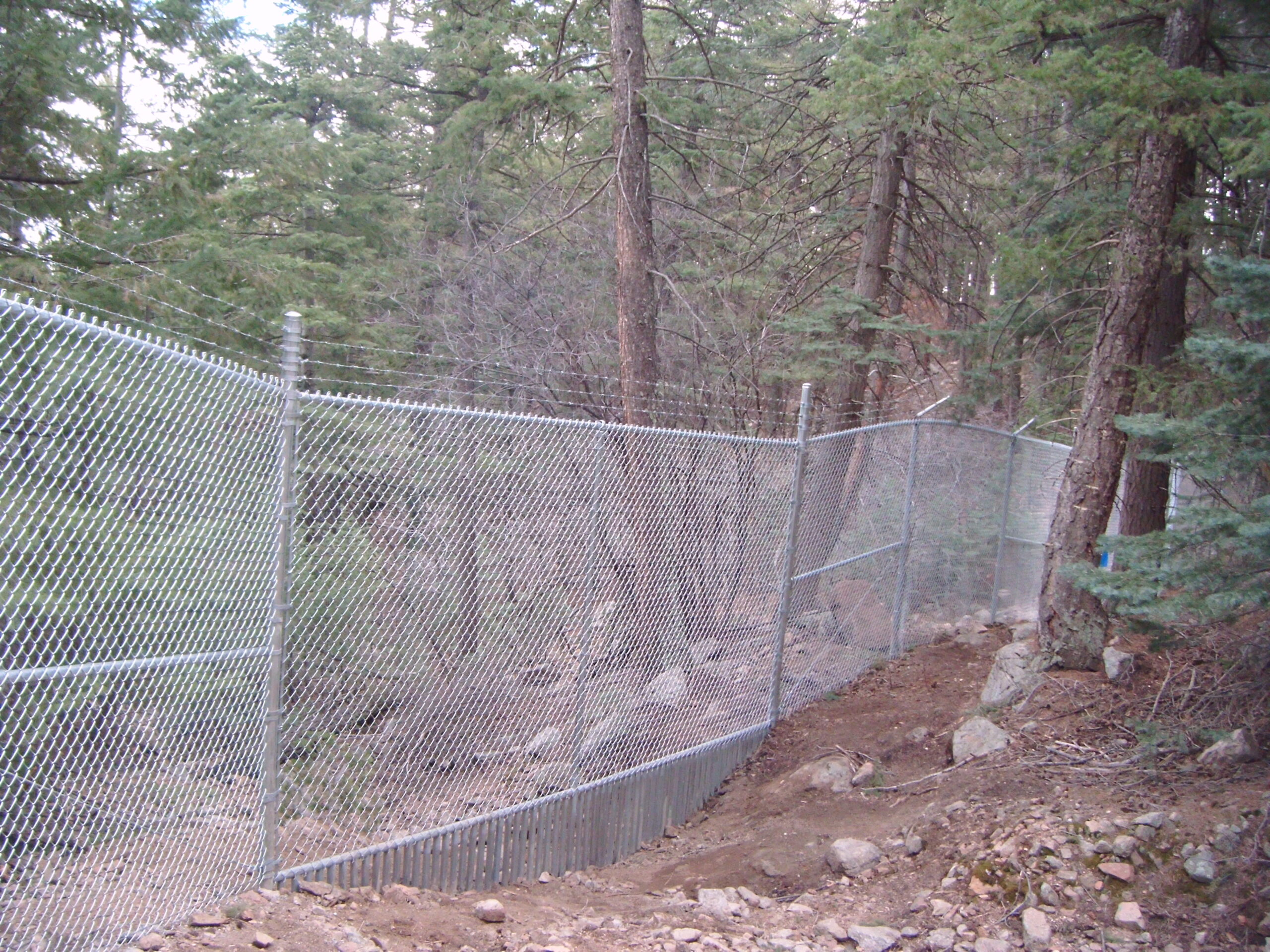 chainlink with animal keeper across creekbed